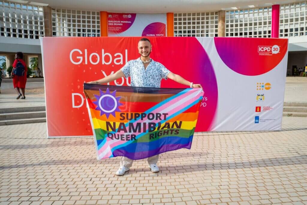 Participants at the Global Youth Dialogue in Cotonou, Benin holds a Support Namibian Queer Rights flag