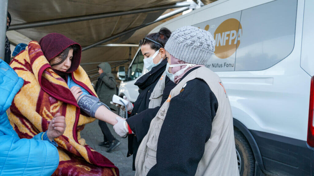 UNFPA worker conducts a health evaluation on a woman.