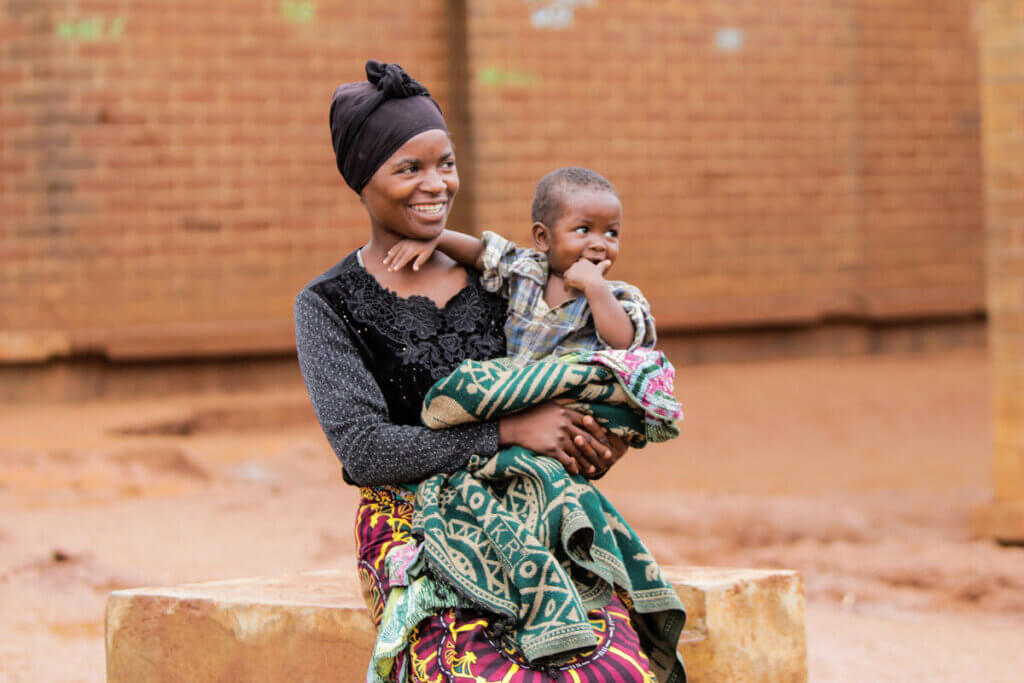 Edith with her son in a temporary displacement camp in Malawi following Storm Freddy.