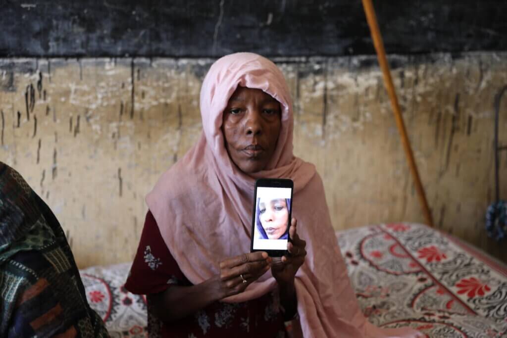 Juliana, who was recently displaced, shows a picture of herself from one year ago, before the war in Sudan began.