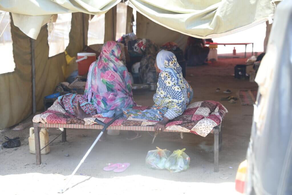 Two women sit together at an IDP camp in Port Sudan after being displaced from the war in Sudan.