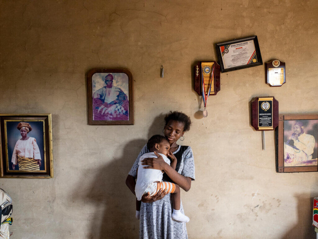 Kehinde soothes her daughter to sleep.