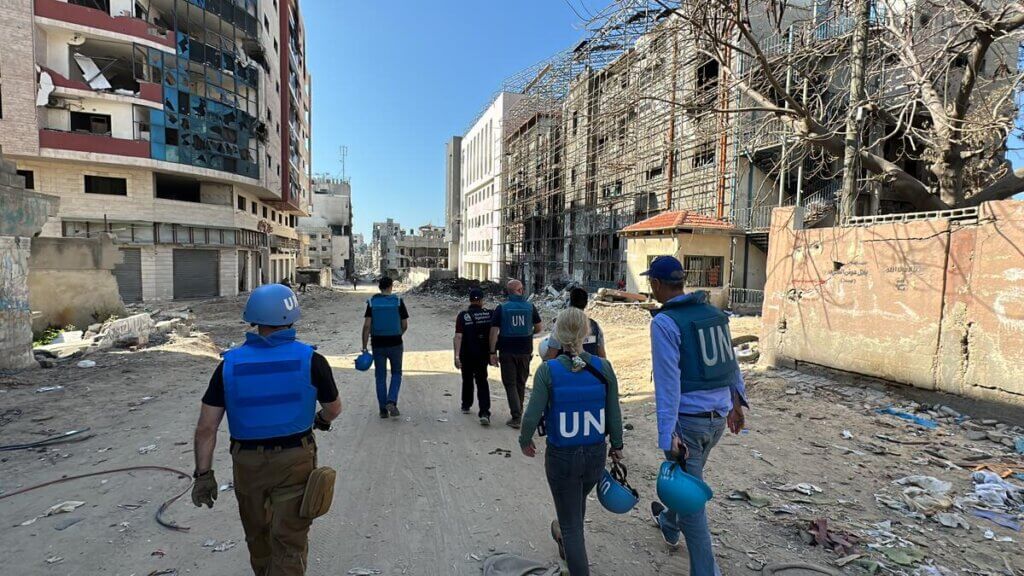 Humanitarian workers walk through the destruction in northern Gaza.