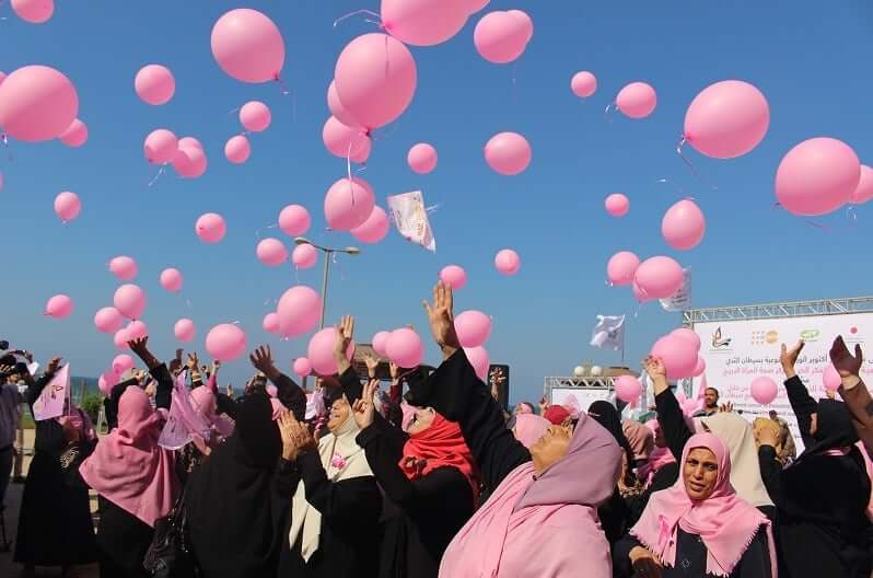 Breast cancer patients and survivors dressed in pink release pink balloons in the sky 