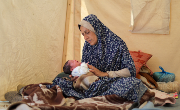 Mother holds her newborn in Gaza