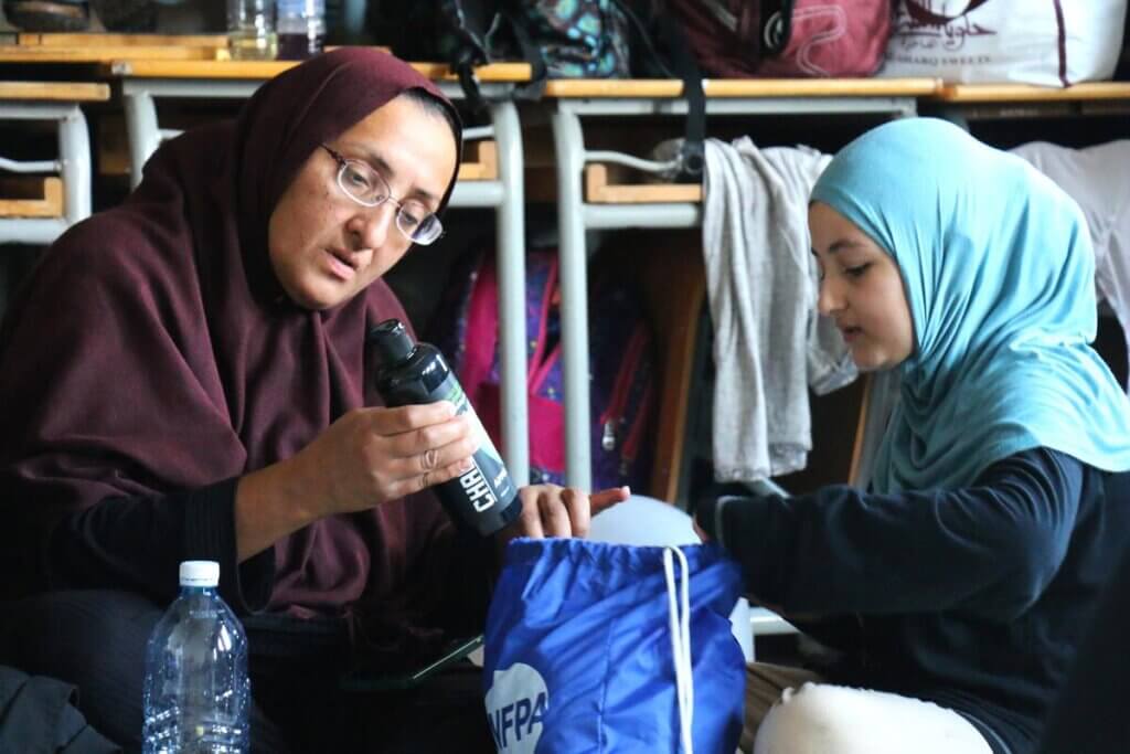 A mother and daughter look through their UNFPA Dignity Kits